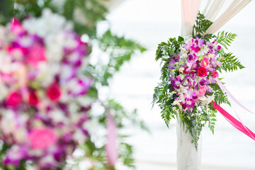 Fototapeta na wymiar Floral arrangement at a wedding ceremony on beach.