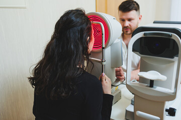 Examination of vision on modern ophthalmological equipment. Eye examination of a woman at an ophthalmologist's appointment using microscopes. Vision treatment at an ophthalmologist appointment