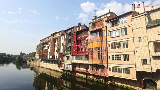 View from bridge of Castres townscape overlooking old colorful houses along Agout river on sunny summer day, Tarn department France