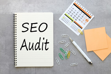 gray background with notepad and calendar .text on paper SEO AUDIT. Business concept.