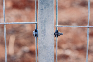 Nut and bolt connected mesh fence with column, Mesh fence of railway, selective focus.