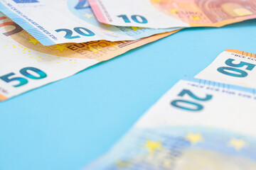 10, 20 and 50 euro bills on a blue background with copy space