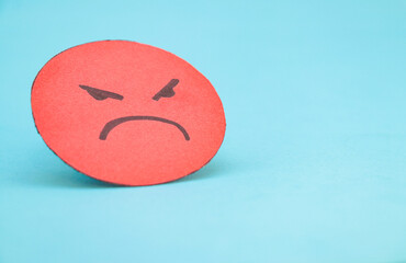 red face of anger, hate or envy isolated on blue background.
abstract concept for mental health