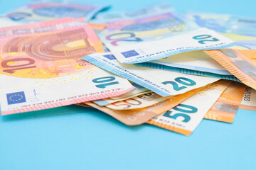 10, 20 and 50 euro bills on a blue background with copy space