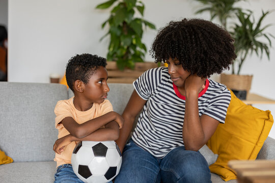 Mother and son spending time together on sofa at home