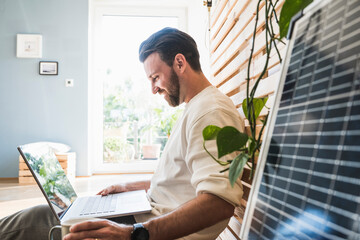 Happy businessman working on laptop at home