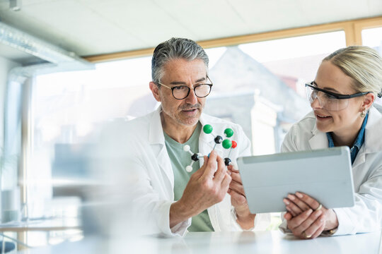 Scientists researching on molecular structure with tablet PC in laboratory - Powered by Adobe