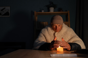 Old man suffers in no heating and no electricity during an energy crisis causing blackouts. No...