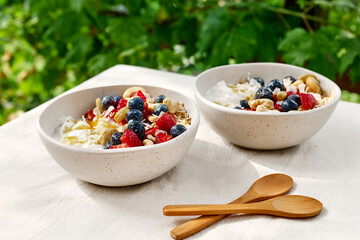 Coconut yogurt granola with strawberry, blueberry and cashew in white bowl. Concept of healthy breakfast, vegetarian meal, dieting, weight loss, healthy eating.