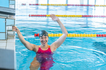 Naklejka premium Woman swimmer happy at the finish of a race in the pool at competition
