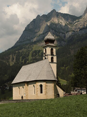 Fototapeta na wymiar historic alpine church, isolated little church on dolomitic landscape. typical mountain religious architecture. Calm and spiritual space in nature.