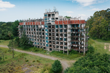 Large abandoned building overgrown with grass and plants. Urbex Lost Places, post apocalyptic concept, aerial view from drone