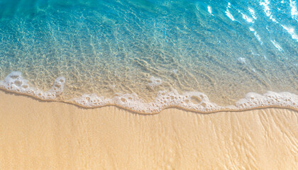 abstract sand beach from above with light blue transparent water wave and sun lights, summer...
