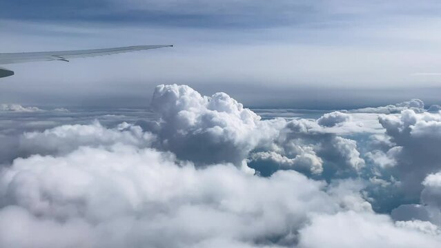 4K,real time,Flying across cloudy sea with wing in the air,airplane window view 