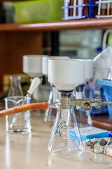 Laboratory glassware with green liquid in a science research laboratory.