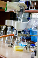 Laboratory glassware with green liquid in a science research laboratory.