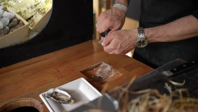 Chef preparing oyster carving it out with a knife
