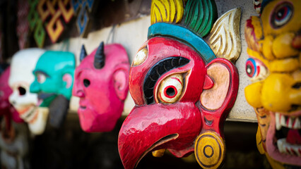 Traditional red mask typical of India and Nepal hanging on a wall as a souvenir for protection, decoration and prosperity