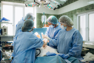 surgeons perfoming surgery operation of abdominal cesarean section during child delivery birth at...