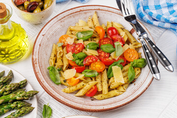 Italian pasta adorned with fresh tomatoes and aromatic basil