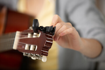 close view of a female hand tuning a guitar