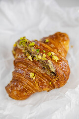 A mouth-watering croissant with a pistachio garnish in close-up
