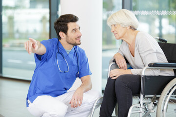 Obraz premium doctor talking to patient in wheelchair and pointing