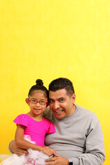 Fototapeta premium Single divorced dad plays with his 4 year old brunette Latina daughter dressed as a ballerina in a leotard and tutu practices her ballet class with her dad