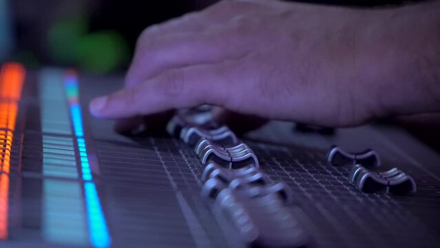 Professional instrumental sound engineer in a TV studio or at a concert. Video production. Record. Close-up music digital mixer for stage setup. Video recording. Video camera.