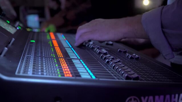 Professional instrumental sound engineer in a TV studio or at a concert. Video production. Record. Close-up music digital mixer for stage setup. Video recording. Video camera.