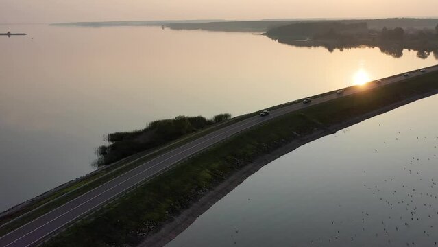 Drone footage of long road with bridge in middle of river at sunset 4k movie. Transport and logistics infrastructure concept