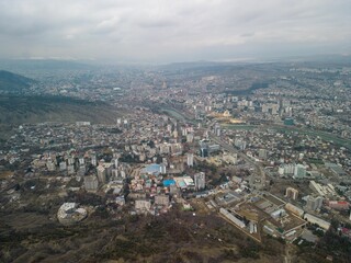 Aerial shot of the cityscape of Tbilisi, Georgia with buildings against a clouded sky