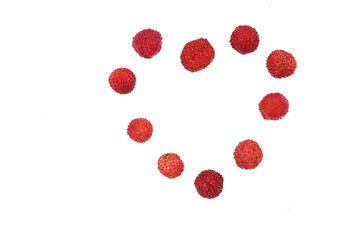 Fragaria berries, wild strawberry heart in a plate isolated on white top view