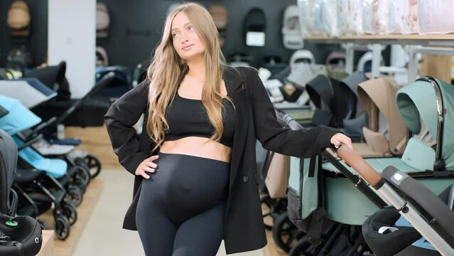 Pregnant Woman Choosing Baby pram in a Store, Preparing to Become Mother