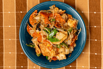 Flat rice noodles with chicken, seafood and vegetables 