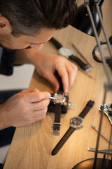 male clockmaker repairing wrist watch