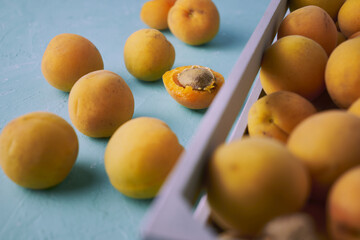 ripe juicy apricots in a wooden box and on the table