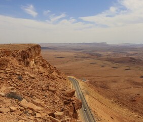 A car moving on the mountain road bending in the desert.
