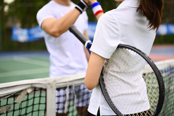 Two young tennis players in sportswear greeting before a tennis match. Sport, training and competition concept