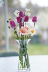 Clear glass vase filled with vibrant, multicolored flowers