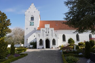 Fototapeta na wymiar Isolated, traditional-style building featuring a white painted facade and a lush green lawn