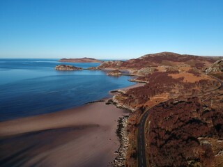 Landscape of the sea surrounded by a grassy shore on a sunny day