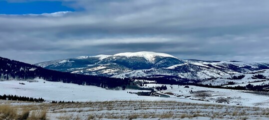 Scenic view of a mountainous landscape covered with a blanket of snow and lush evergreens