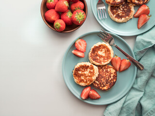 Sweet cheese pancakes on plate served strawberries. Cottage cheese pancakes, syrniki, ricotta...