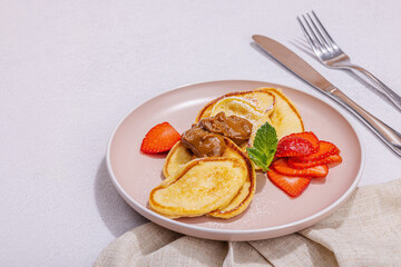 Cottage cheese pancakes, syrniki, curd fritters with strawberry, mint and powdered sugar on plate
