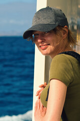 Portrait of beautiful young woman with cap on cruiser ship at Canary islands, travel and adventure...