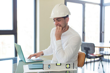 young handsome man feeling scared, worried or angry and looking to the side. architect concept