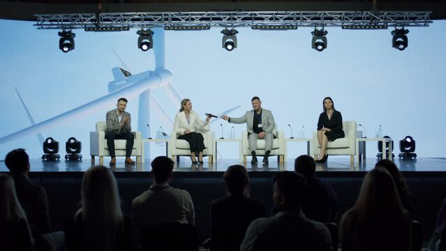 Group of 4 experts speakers are having a conversation on stage during sustainable green eco energy conference 