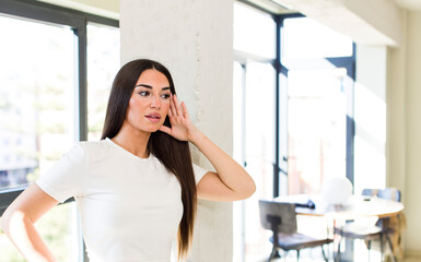 Obraz premium young adult pretty woman smiling, looking curiously to the side, trying to listen to gossip or overhearing a secret
