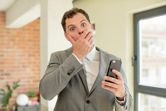 covering mouth with a hand and shocked or surprised expression. smartphone concept